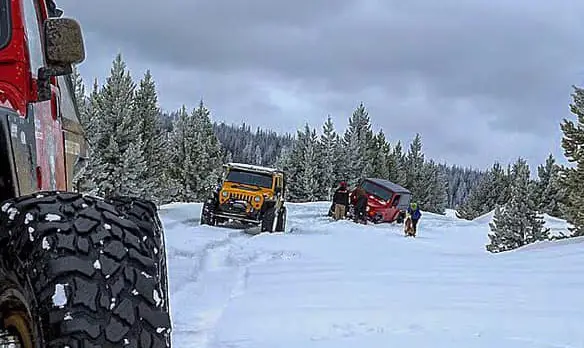 Jeep recovery in the snow. Using recovery gear for trail safety.