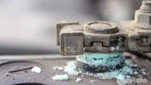 Close-up view of battery terminal with moderate corrosion and powdery green residue.