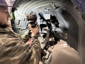 TNT Customs mechanic installs a Rough Country 2-inch leveling kit on a truck inside the shop.